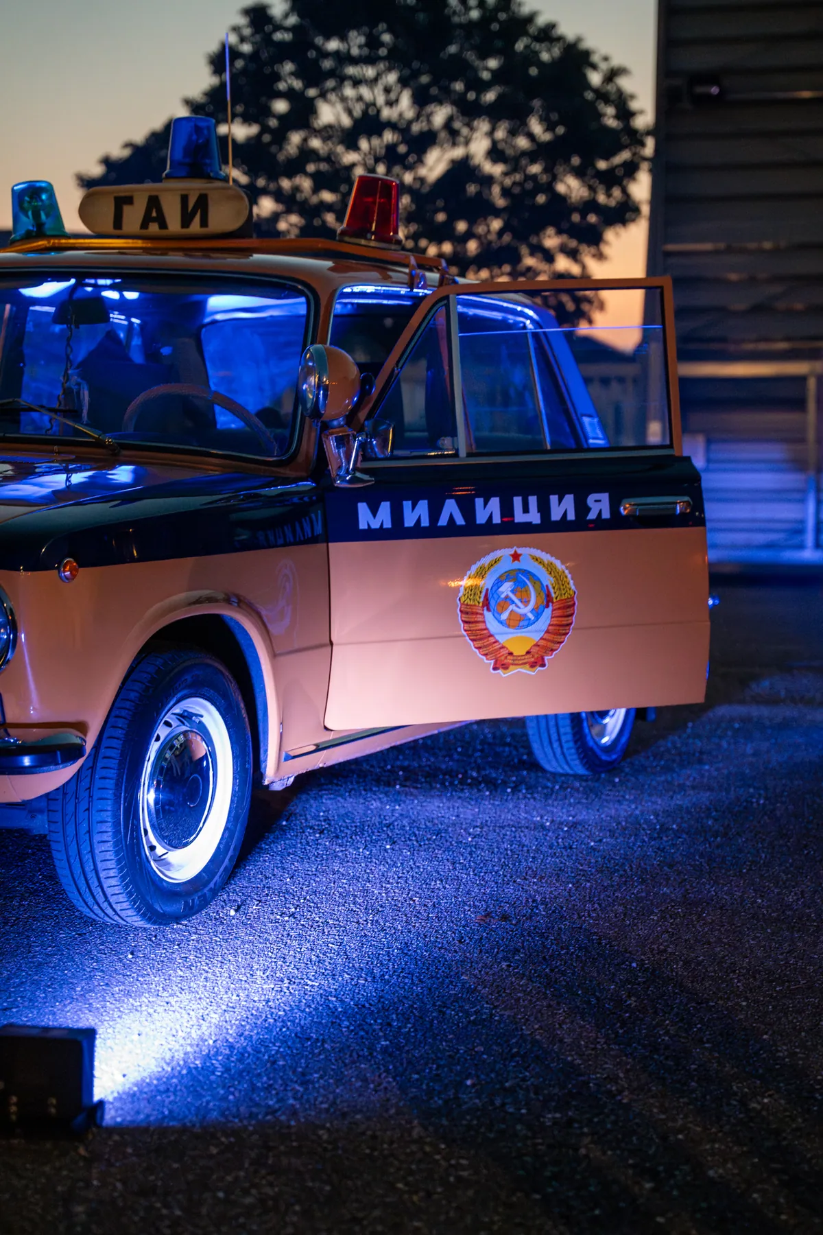 Orangefarbener Lada der Miliz vor dem Eingang