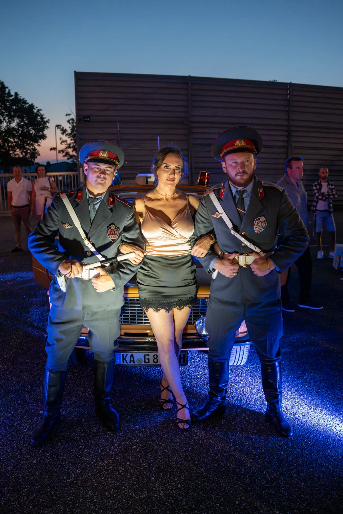 Gäste mit Darstellern in sowjetischer Milizuniform vor dem Lada
